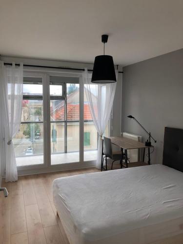 une chambre avec un lit, un bureau et une fenêtre dans l'établissement Appartement Venise 2 chambres, à Reims