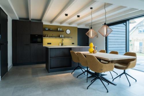 a kitchen with a dining table and chairs at Sun (6p) in Ballum