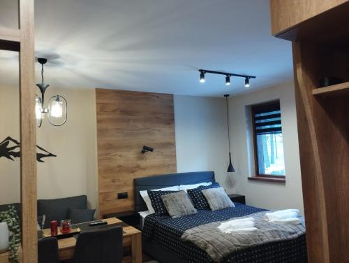 a bedroom with a blue bed and a table at студио Е 13 in Pamporovo
