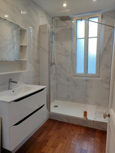 une salle de bain blanche avec une douche et un lavabo dans l'établissement Logement entier - Centre Fécamp - 67 Vanessa, à Fécamp