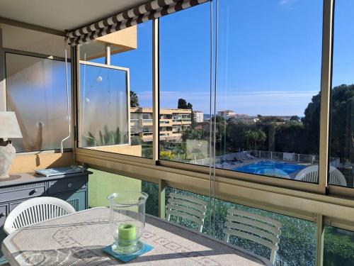 Cette chambre dispose d'une table et d'une grande fenêtre avec vue. dans l'établissement Le Beachcomber, à Antibes