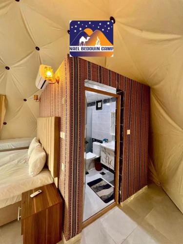 a room with a tent with a bed and a mirror at NAEL BEDOUIN Camp in Wadi Rum