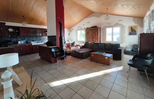 Il comprend un grand salon avec un canapé et une cuisine. dans l'établissement Maison 400m océan, à Brem-sur-Mer