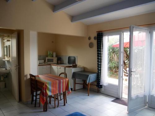 une cuisine avec une table et une cuisine avec une porte dans l'établissement ღ La Pause Retaise - Proche Plage, Jardin & Wifi, au Bois-Plage-en-Ré