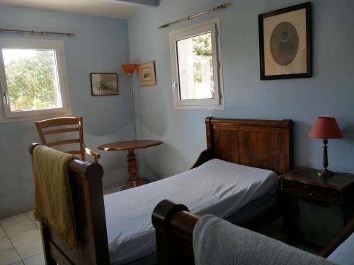 une chambre avec un lit et une table et deux fenêtres dans l'établissement ღ La Pause Retaise - Proche Plage, Jardin & Wifi, au Bois-Plage-en-Ré