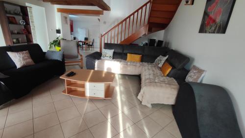 a living room with a couch and a coffee table at Brocéliande calme breton, spa, wifi, amazon-disney tv, 4 lits, Freebox revolution,draps, café, thé in Guer
