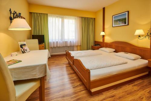 a hotel room with two beds and a table at Flair-Hotel Zum Benediktiner in Schwarzach am Main