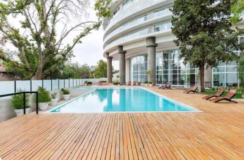a swimming pool in front of a building at Calido departamento Parque in Villa Marini