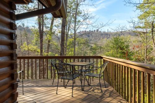 a table and chairs on a deck with a view at Bear Hideaway Cozy 3BR Cabin in Sevierville