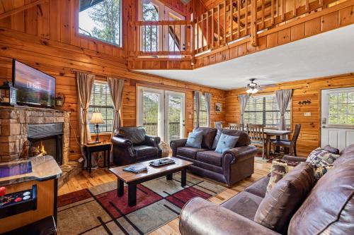 a living room with leather furniture and a fireplace at Bear Hideaway Cozy 3BR Cabin in Sevierville