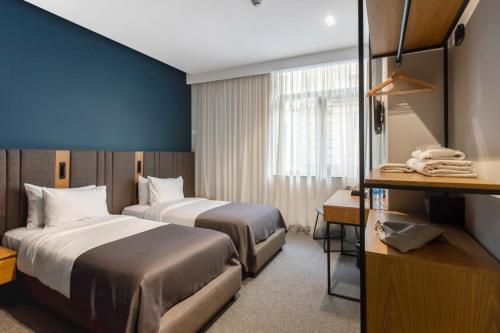トビリシにあるGraf Hotelのベッド2台と机があるホテルの部屋