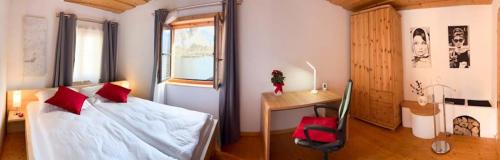 a bedroom with a bed with red pillows and a desk at Appartementgitti in Hallstatt