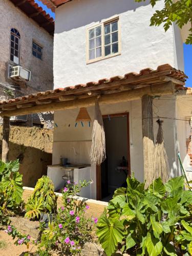 a white house with a door and some plants at Chalé caiçara aconchegante in Paraty