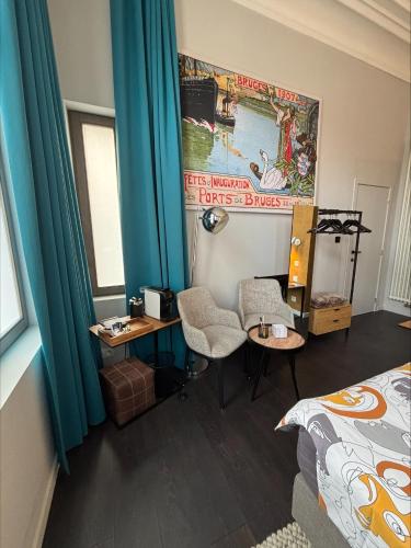 a room with a bed and a desk and a bed and a bed at B&B Het Havenhuis in Bruges