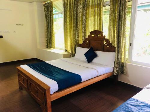 a bedroom with a large bed in a room with windows at Ghala Homestay in Anachal