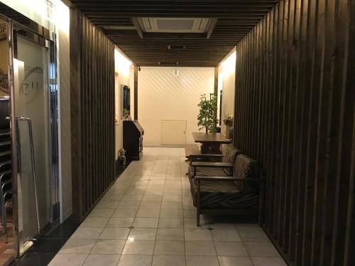 a hallway with chairs and a table in a building at skホテル in Ichibachō