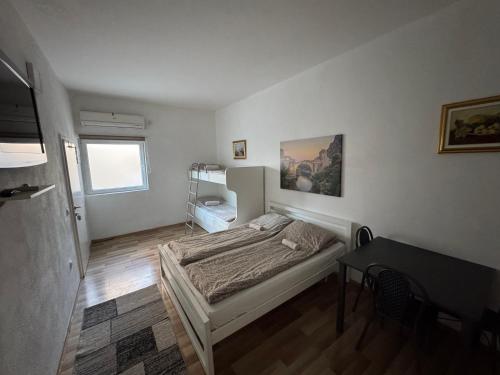 a bedroom with a bed and a table in it at Villa Anja Apartments in Mostar
