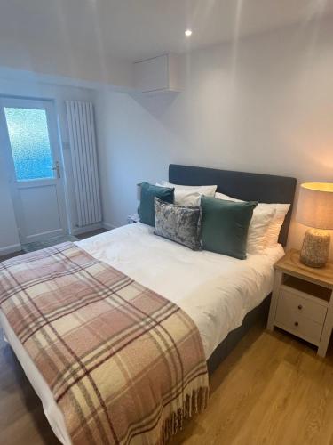 a bedroom with a bed with pillows and a lamp at The Little Fern in Oxford