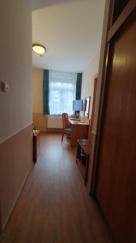 a hallway of an office with a desk and a window at Hotel Baross in Győr