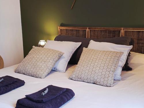 a bed with white pillows and blue towels on it at Boho Nest in Rosporden