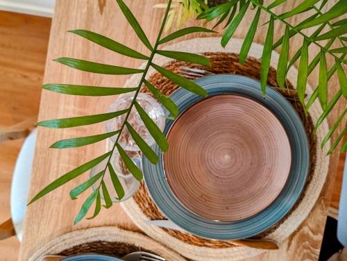 a wooden table with a bowl and a plant on it at Boho Nest in Rosporden