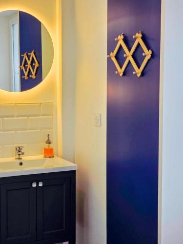 a bathroom with a sink and a mirror at Boho Nest in Rosporden