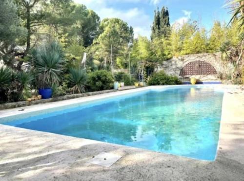 une piscine avec de l'eau bleue dans une cour dans l'établissement La Tour, à Béziers