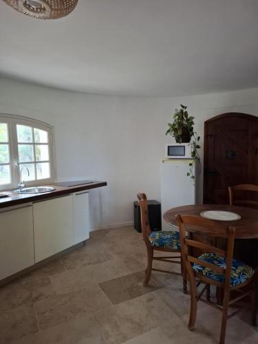 une cuisine avec une table, des chaises et un évier dans l'établissement La Tour, à Béziers