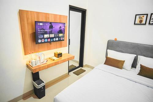 a bedroom with a bed and a flat screen tv at SALU AMAANA Residence Syariah in Wonosobo