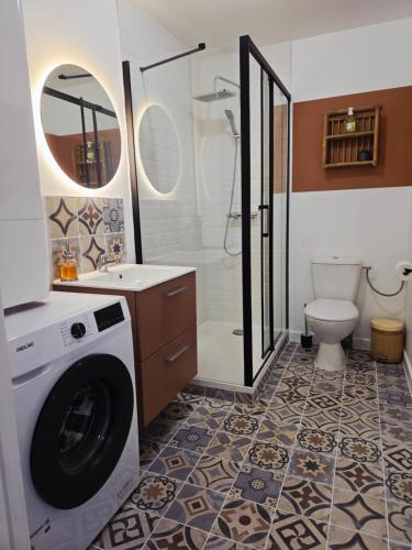 a bathroom with a washing machine and a toilet at Boho Nest in Rosporden
