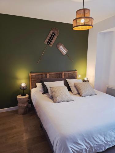 a bedroom with a large bed with a green wall at Boho Nest in Rosporden