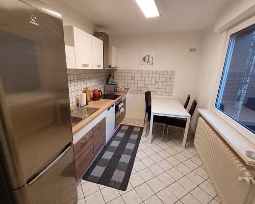 a small kitchen with a table and a refrigerator at Komfortable 3-Zimmer-Wohnung in Neubeckum in Beckum