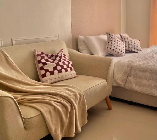 a living room with a couch and a chair with pillows at Affordable Staycation near Airport and beach in Suba