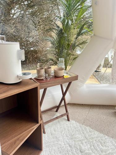 une table avec des bols à côté d'une fenêtre dans l'établissement Le Dôme du Lac, à Prouilly