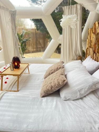 - un lit blanc avec des oreillers et une table dans l'établissement Le Dôme du Lac, à Prouilly