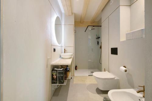 a white bathroom with a toilet and a sink at Cozy Sommavilla Residence in Brenzone sul Garda