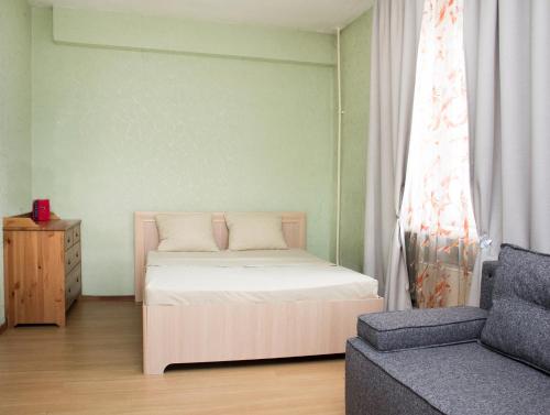モスクワにあるApartLux Profsoyuznayaの小さなベッドルーム(ベッド1台、ソファ付)
