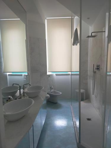a bathroom with two sinks and two toilets and a shower at Hotel Excelsior in Vasto