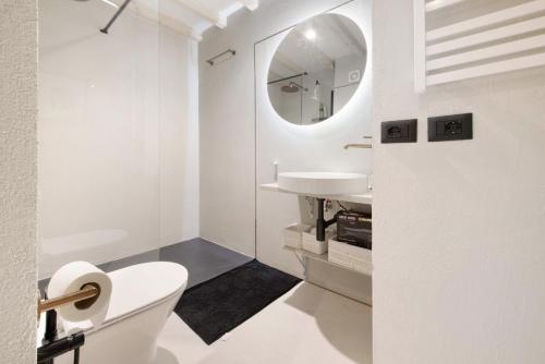 a white bathroom with a toilet and a sink at Cozy Sommavilla Residence in Brenzone sul Garda