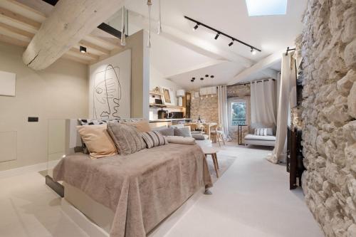 a living room with a bed and a stone wall at Cozy Sommavilla Residence in Brenzone sul Garda