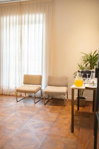 two chairs and a table in a room with a window at Hotel Boutique Sidonia in Jerez de la Frontera