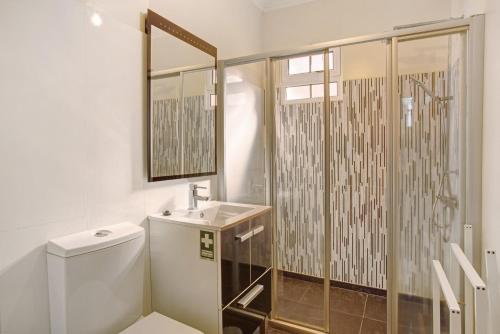 a bathroom with a shower and a toilet and a sink at Cristina Grand in São Vicente