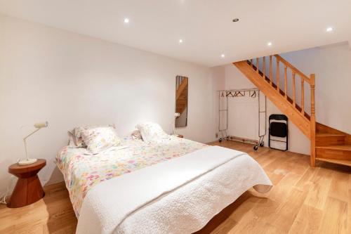 - une chambre blanche avec un lit et un escalier dans l'établissement La Collégiale - Paris 5ème arrondissement, à Paris