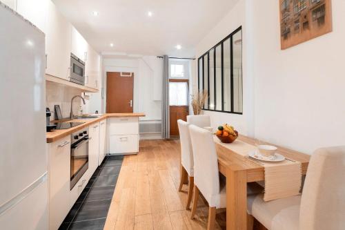 une cuisine et une salle à manger avec une table et des chaises en bois dans l'établissement La Collégiale - Paris 5ème arrondissement, à Paris