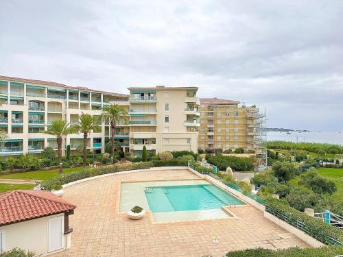 - une vue sur la piscine en face d'un bâtiment dans l'établissement Appartement 1 chambre Vue mer piscine parking, au Golfe-Juan