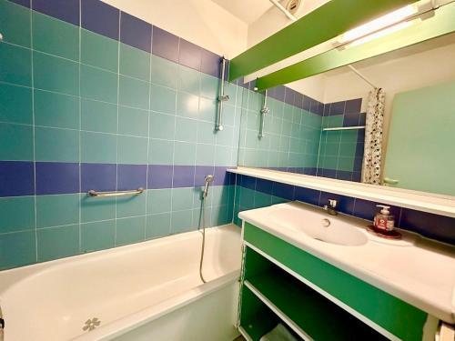 une salle de bain avec un lavabo, une baignoire et un miroir dans l'établissement Appartement 1 chambre Vue mer piscine parking, au Golfe-Juan