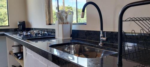 a kitchen with a sink and a counter top at Refúgio na Serra dos Garcias in Aiuruoca