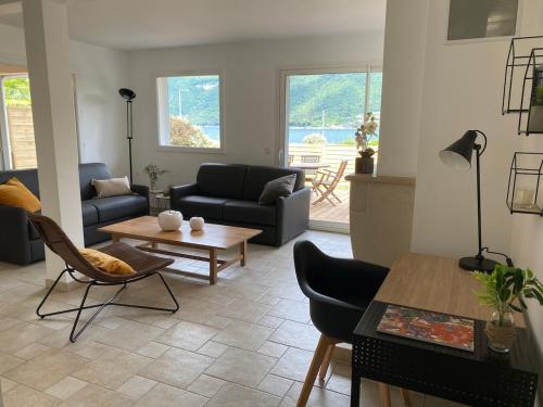 a living room with a couch and a table at Casa Recto, au bord du lac d'Annecy avec vue in Doussard