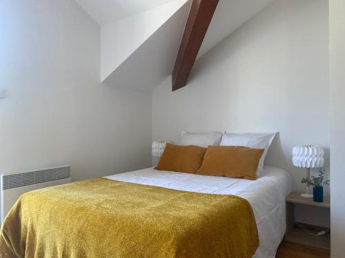 a bedroom with a bed with a yellow blanket at Casa Recto, au bord du lac d'Annecy avec vue in Doussard