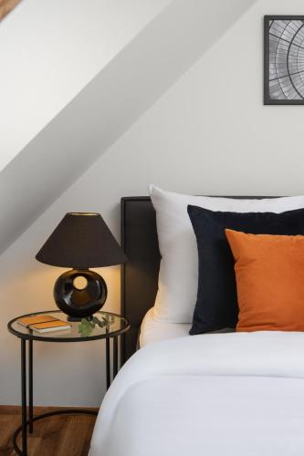 a bedroom with a bed and a table with a lamp at Old Town Apartment Spilberk by goodnite cz in Brno